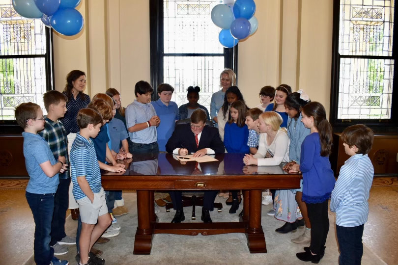 Mannsdale Upper Elementary fourth graders watch Gov. Tate Reeves sign House Bill 1027 into law, designating the blueberry as the official fruit of Mississippi.